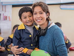 Global Hope staff smiling with local child